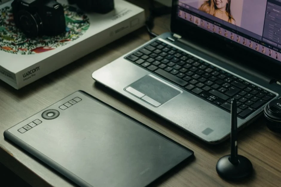 Close-up shot of an orange credit card held above a laptop, emphasizing digital payment.
